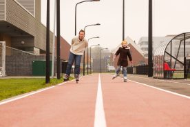 Man en meisje skeeleren op een fietspad in Maastricht