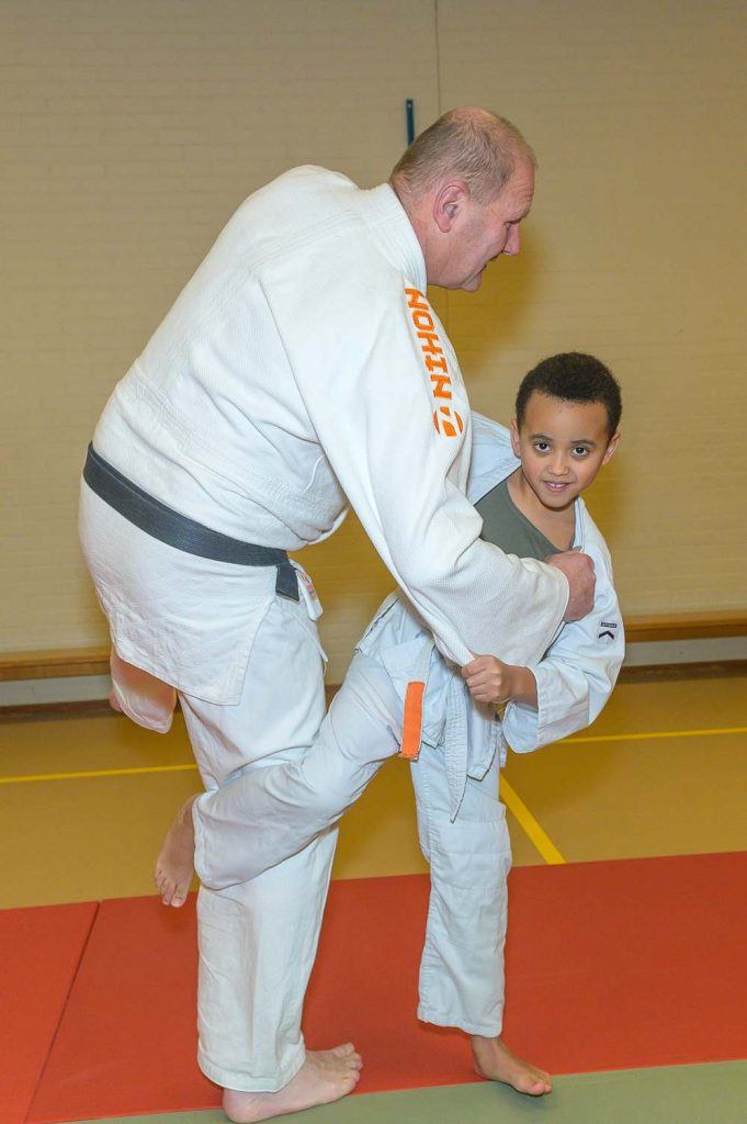 Youngster is being teached in Judo by coach