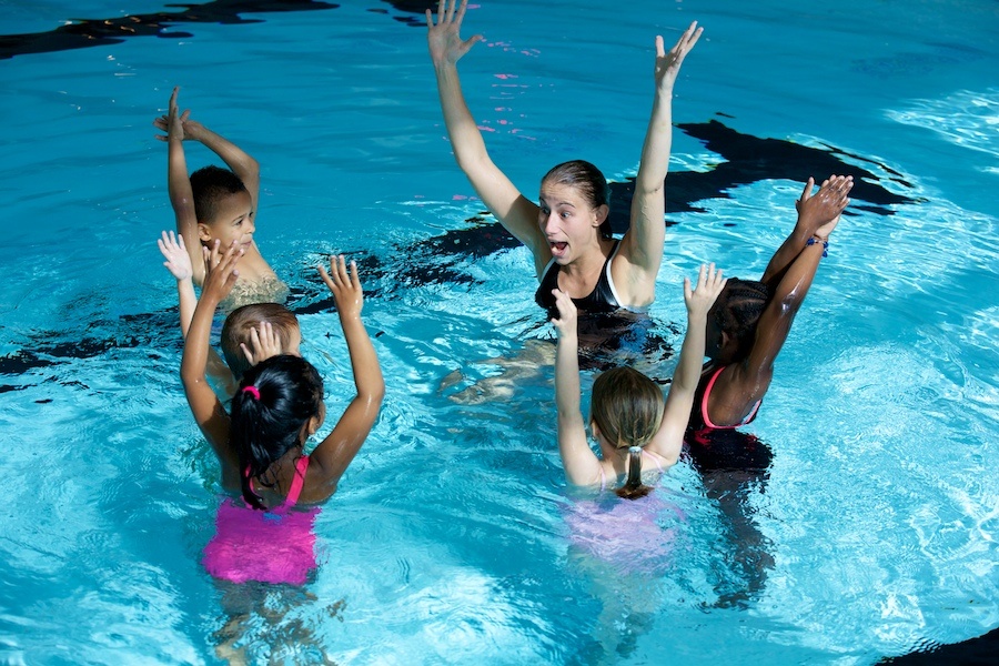 choach and children in swimming pool